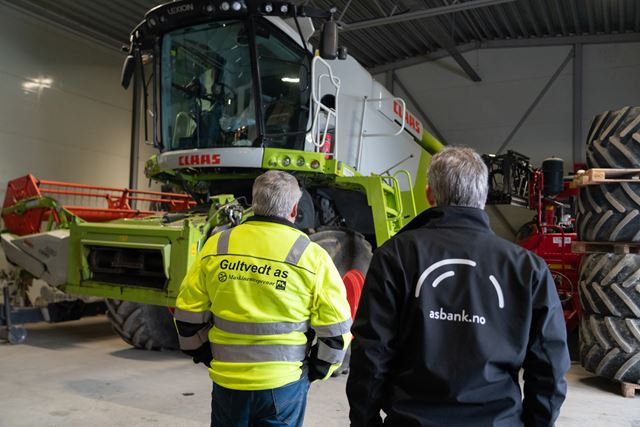 To menn som står og ser på en skurtrøsker. Morten Gultvedt og Petter Agnalt fra Askim & Spydeberg Sparebank.